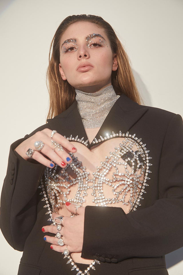 Woman wearing a black blazer with jeweled embellishments and rings