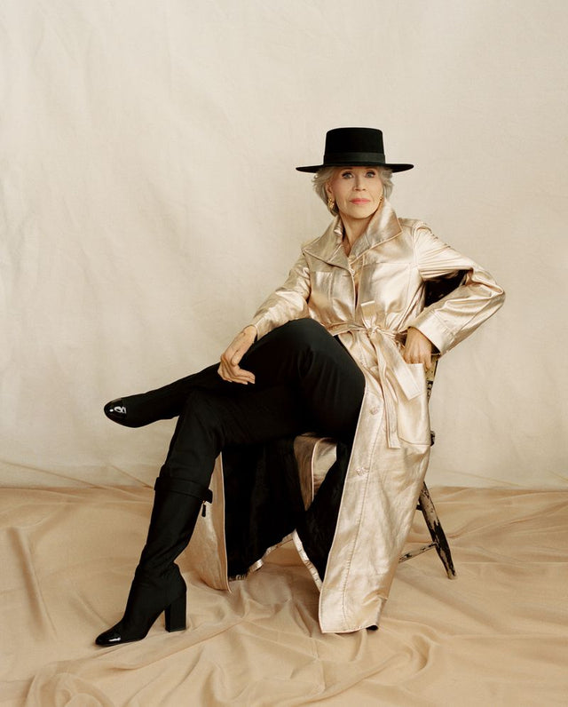 Woman in a black hat wearing a metallic coat and boots