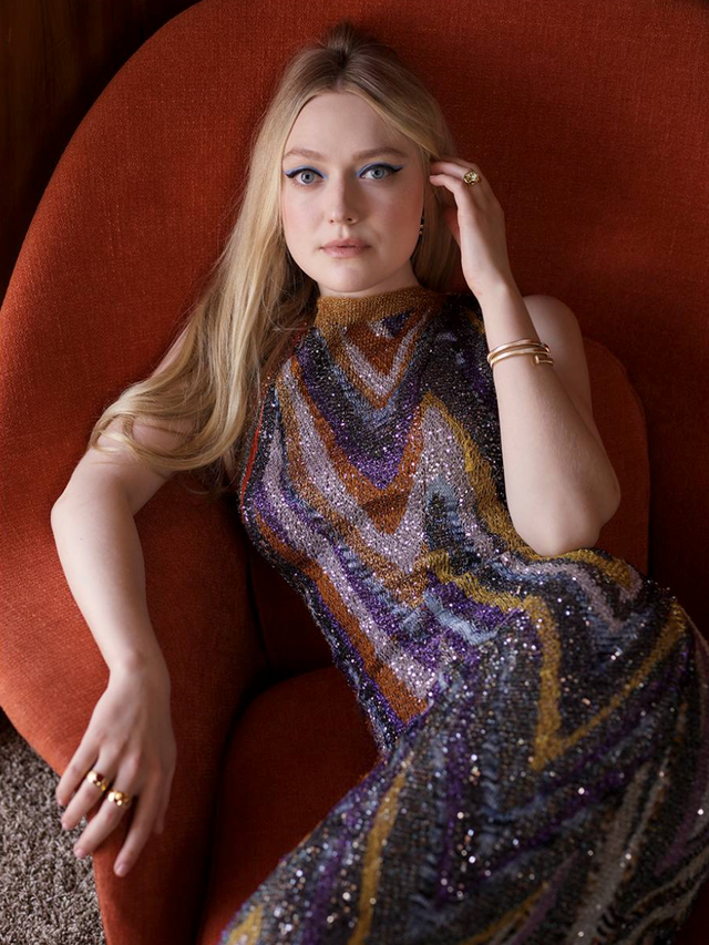 Woman seated in a red chair wearing a sequined dress