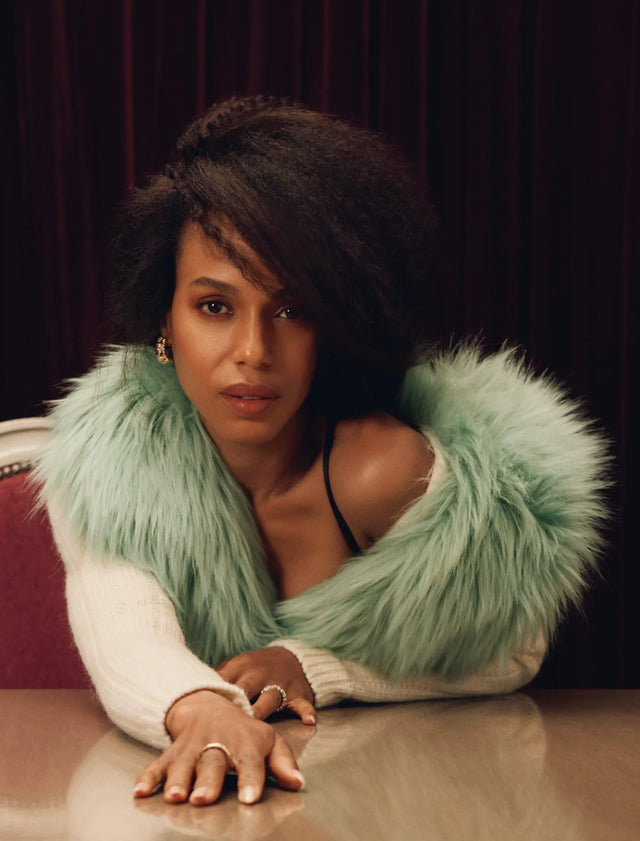 Woman in mint green fur collar leaning on table