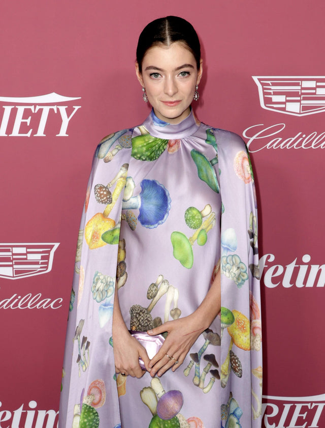 Woman posing in a colorful patterned dress at an event