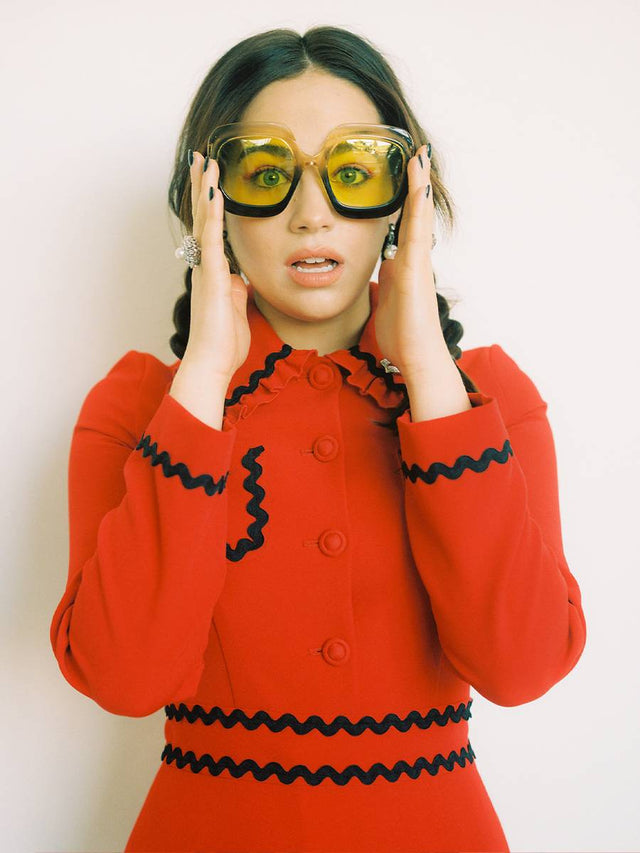 Person wearing yellow sunglasses and a red ruffled outfit