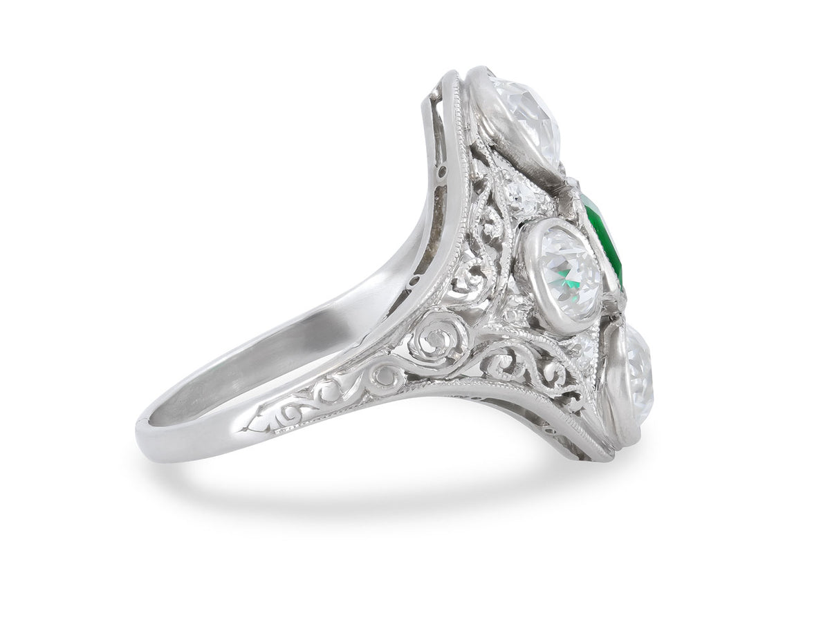 Side view of a platinum ring with emerald and diamonds