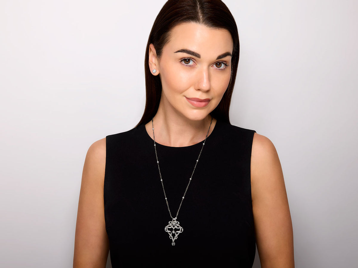 Model wearing a diamond and pearl pendant necklace