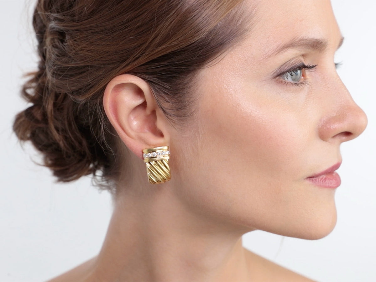 Woman wearing a fluted gold half hoop diamond earring