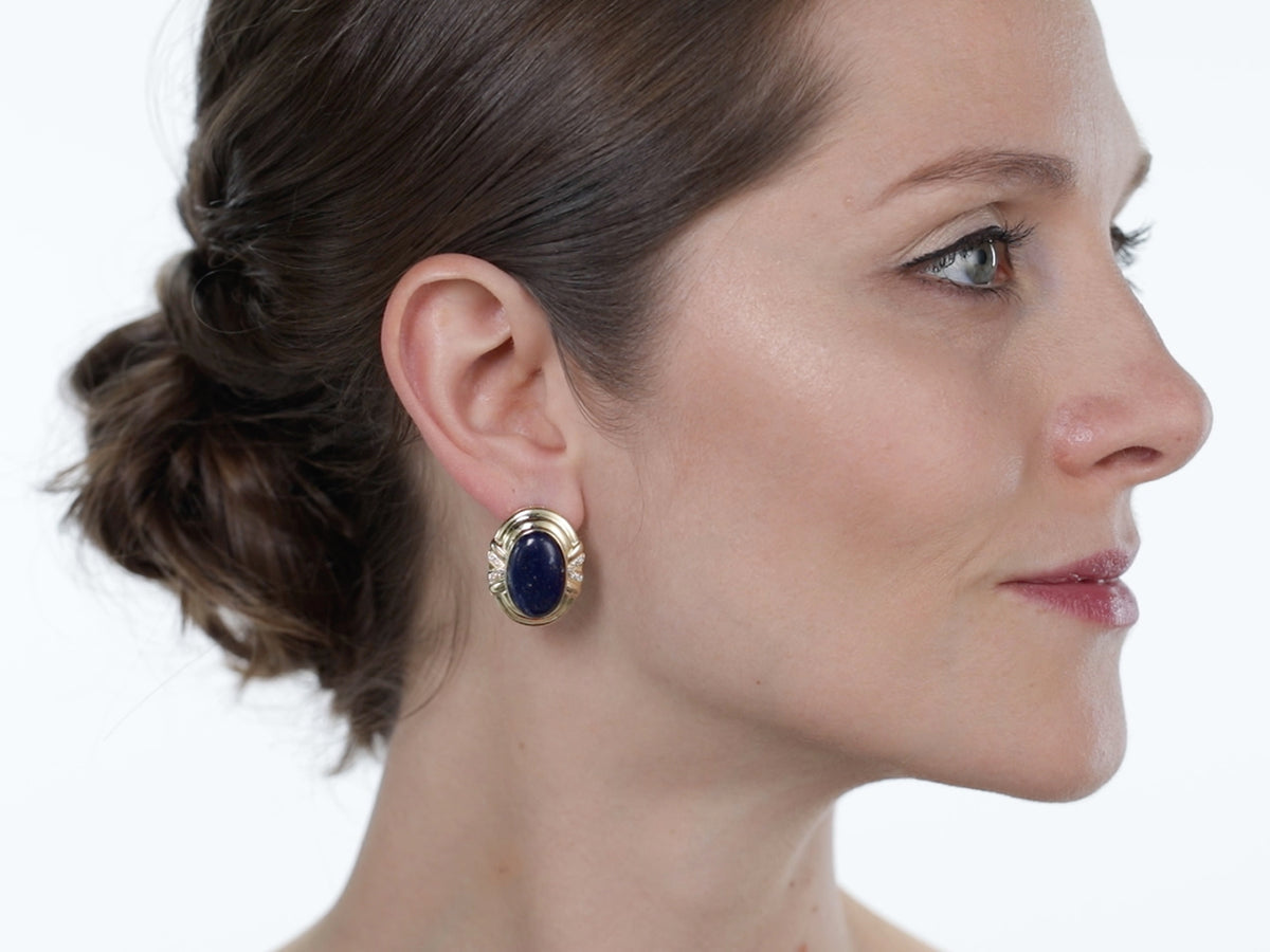 Woman in profile wearing an oval lapis gold earring