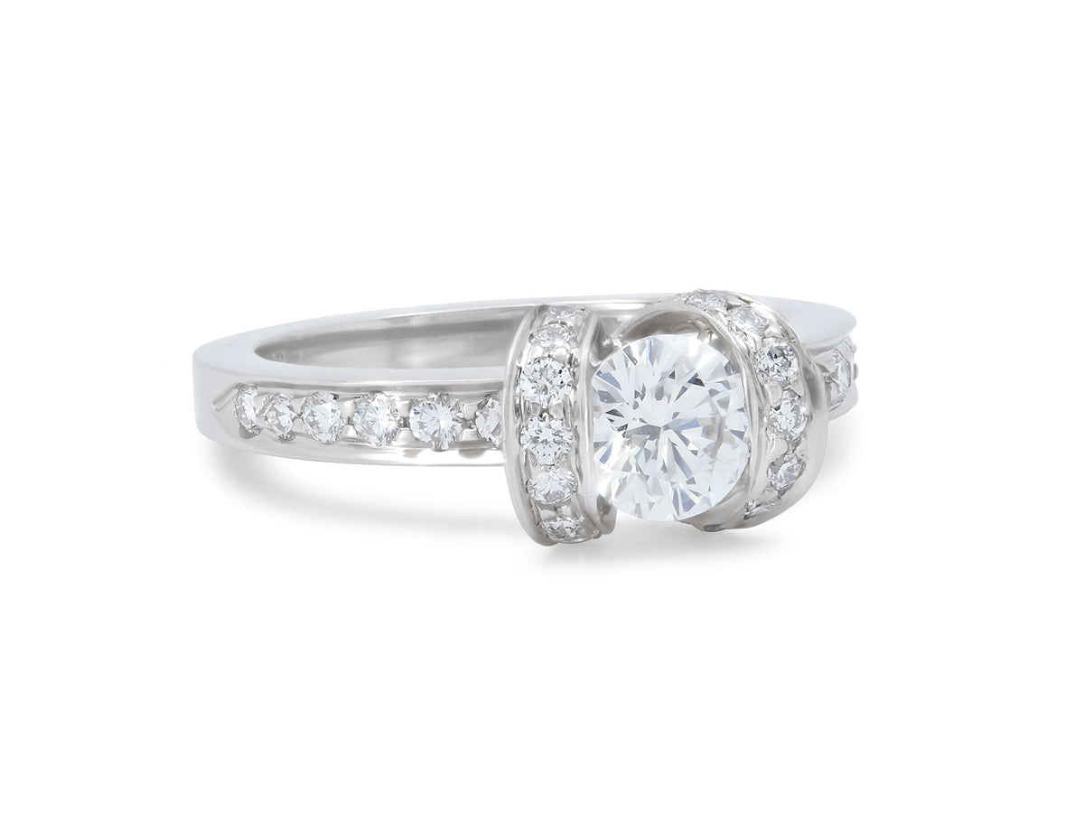 Platinum diamond ring with ribbon motifs and round center stone