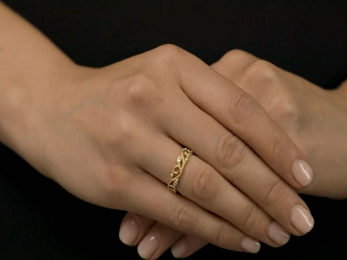 Close up of a hand wearing a gold vine ring with diamonds