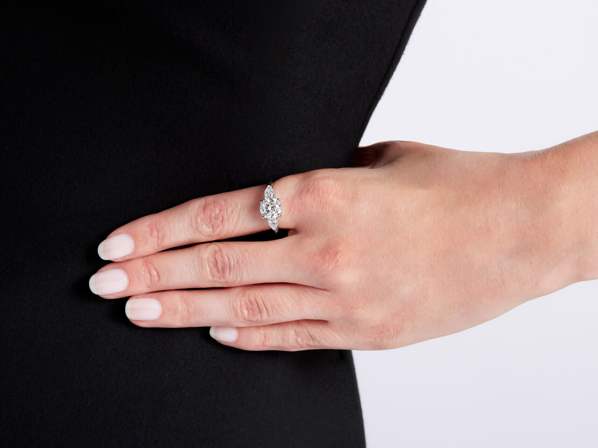 Diamond ring with pear shaped side stones on hand