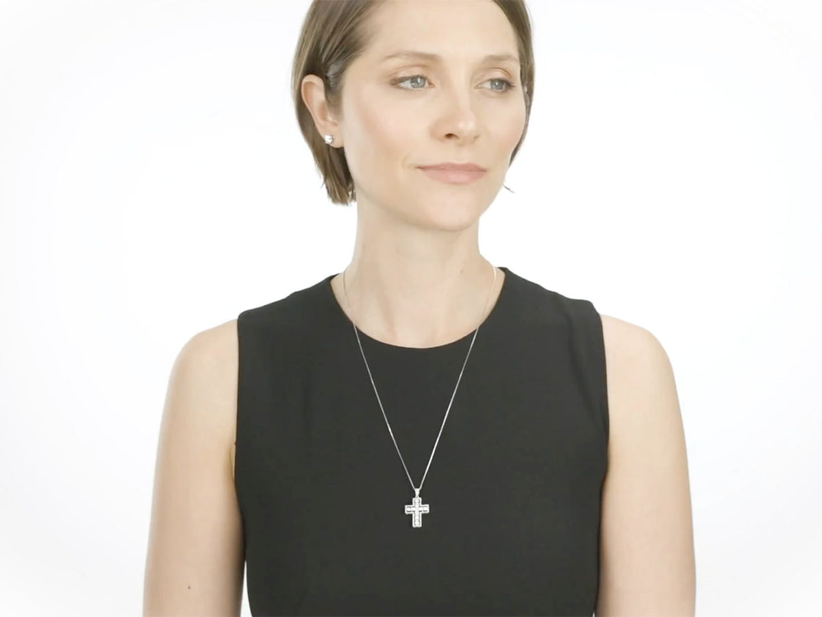 Woman wearing a diamond cross pendant in white gold