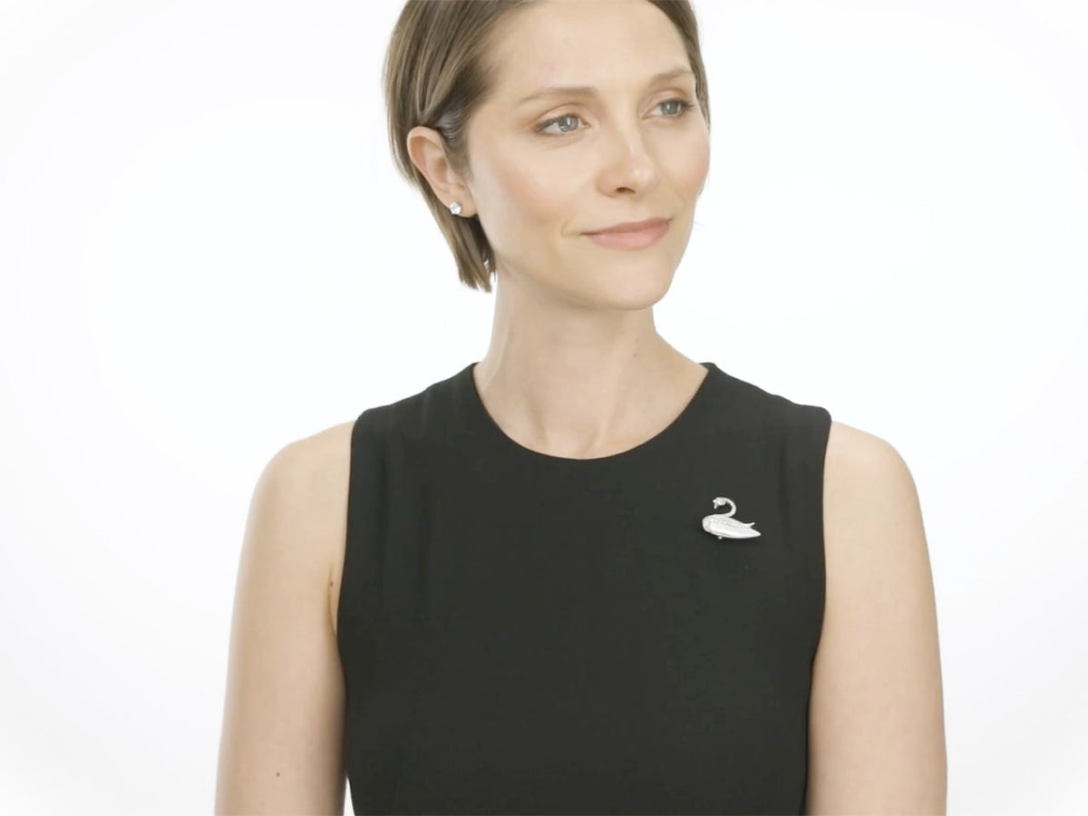 Woman wearing a swan brooch on a black dress
