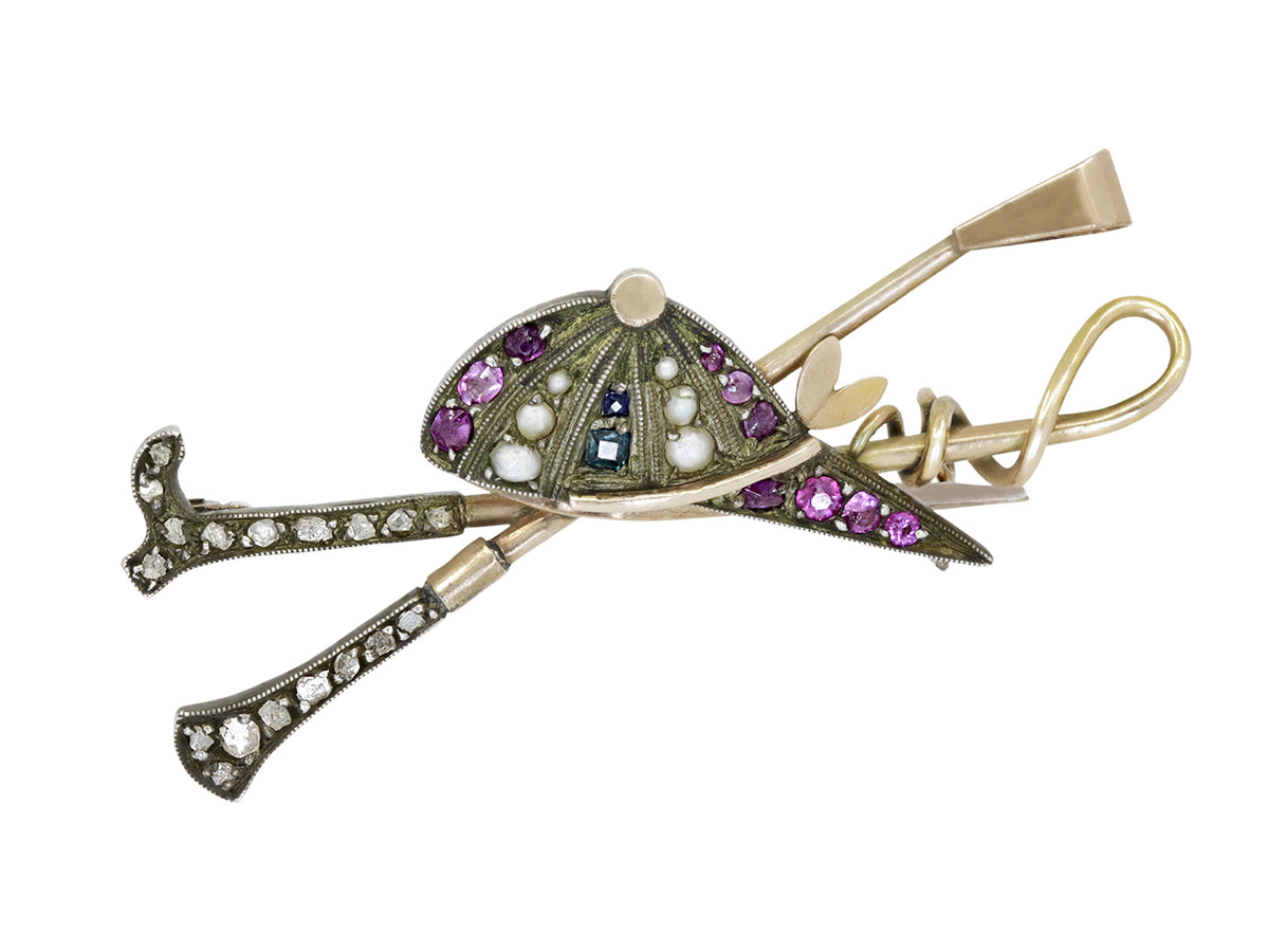Antique equestrian brooch with jeweled helmet and riding crop