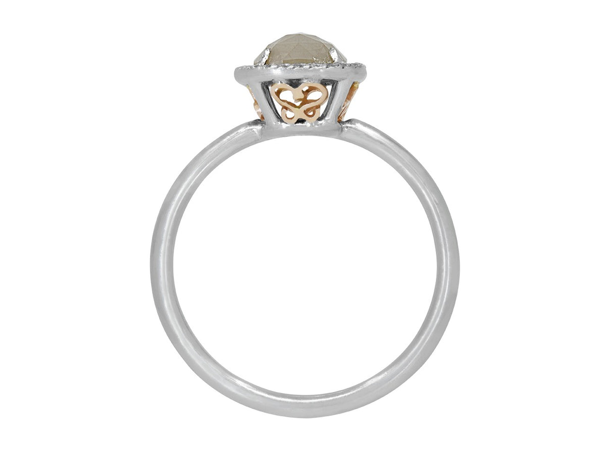 Profile view of white gold halo ring with raw diamond