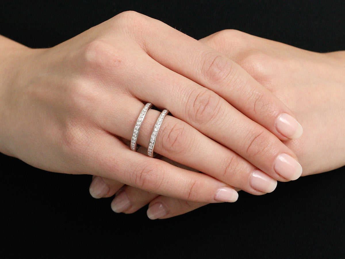 Hands wearing a double diamond band in white gold