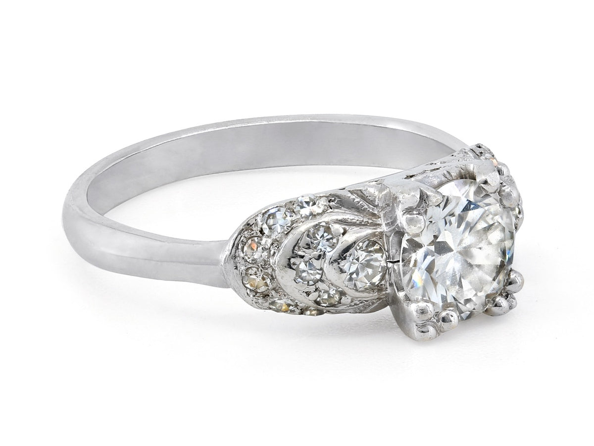 Platinum diamond ring with ornate stepped shoulders