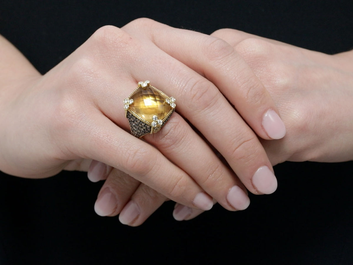 Hand wearing a gold citrine and diamond ring
