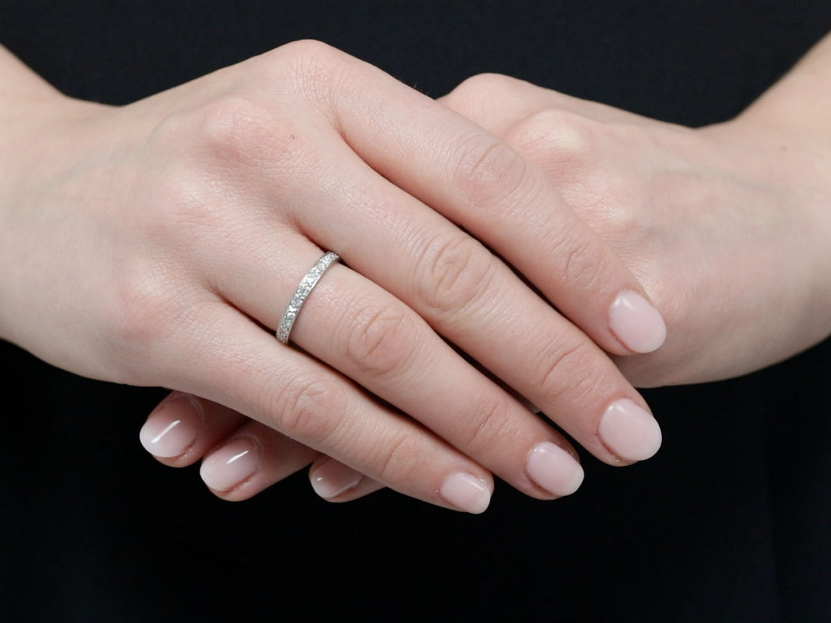 Platinum diamond eternity band worn on folded hands