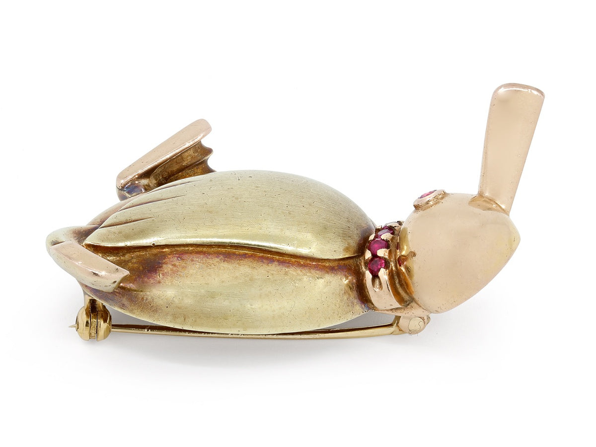 Side view of a 14K gold duck pin with ruby accents