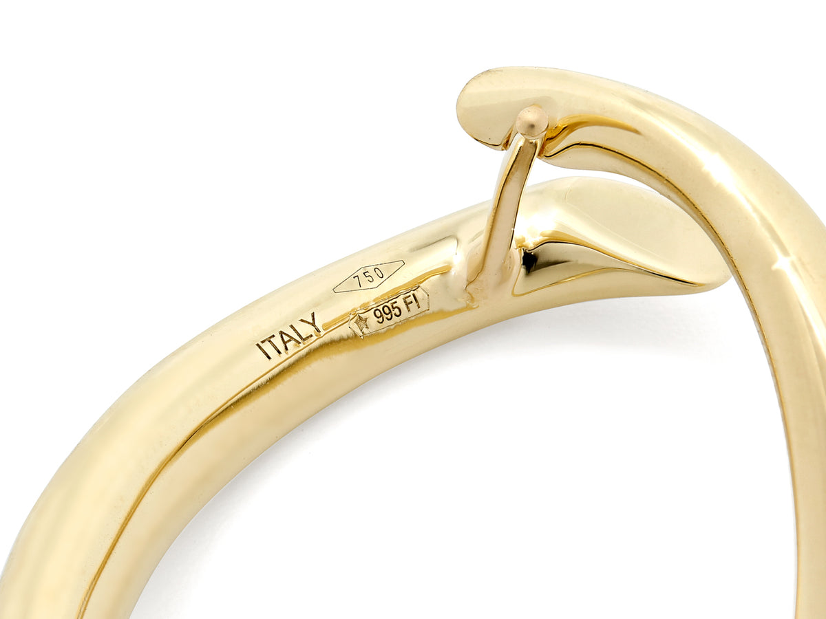 Closeup of polished 18K gold hinged loop earring clasp