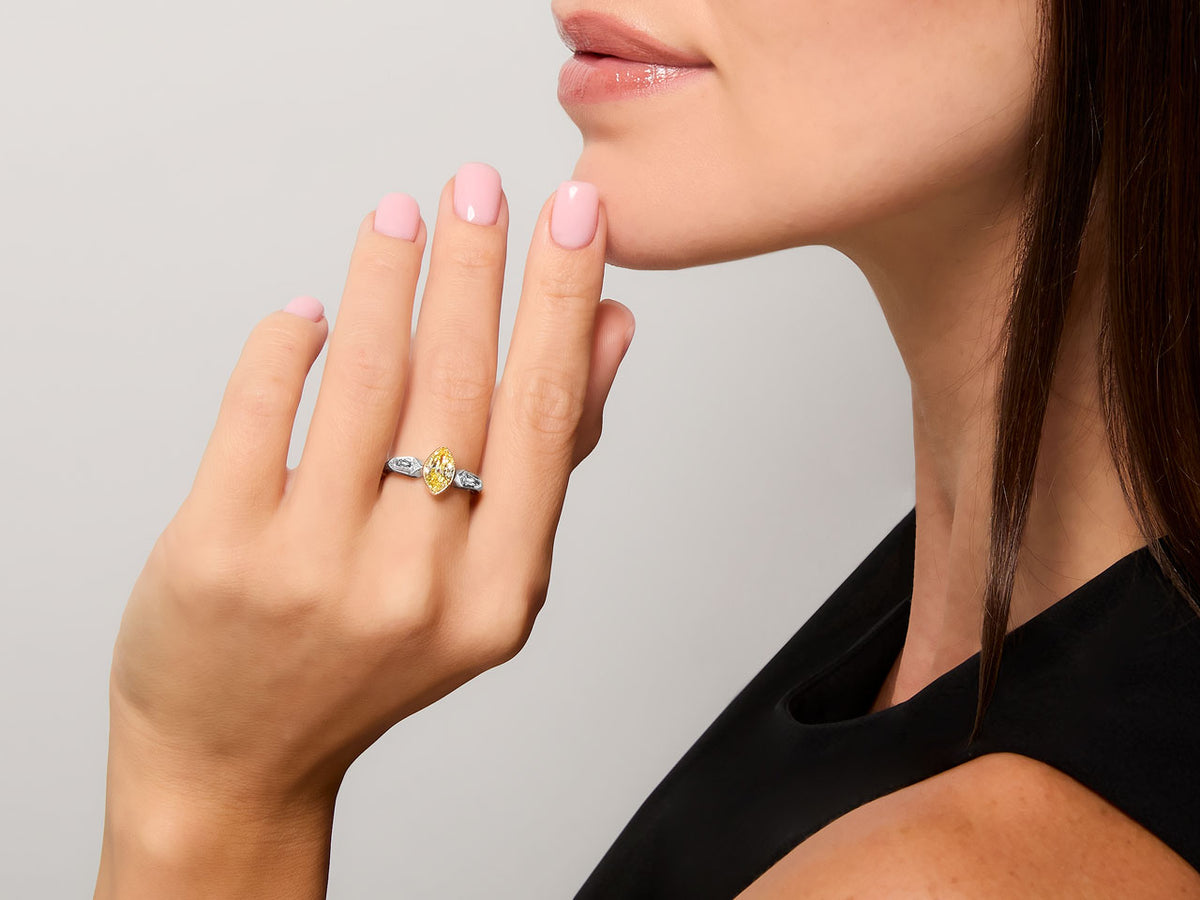 Woman wearing a marquise yellow diamond ring with diamond accents
