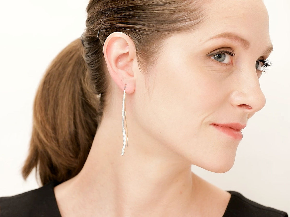Woman wearing a long gold snake dangle earring