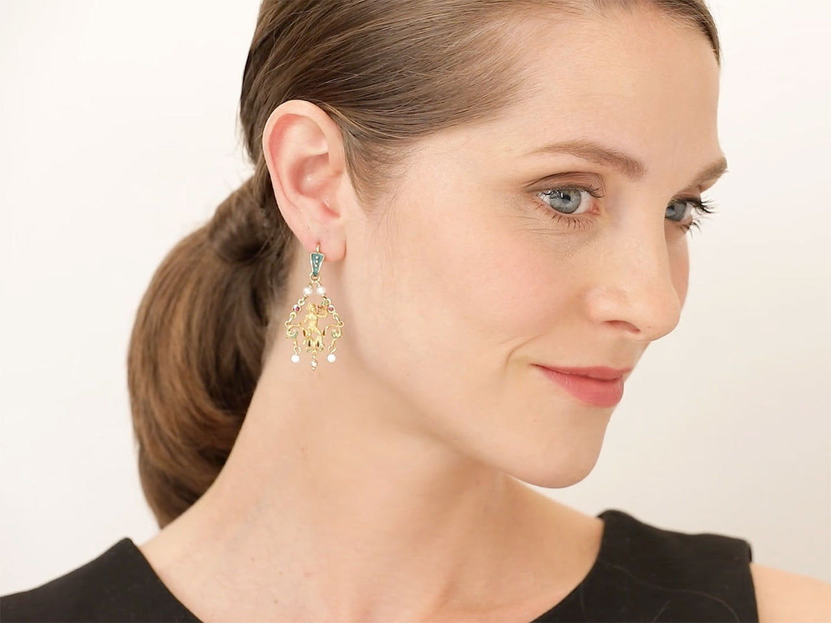 Woman wearing an ornate Bacchus enamel drop earring