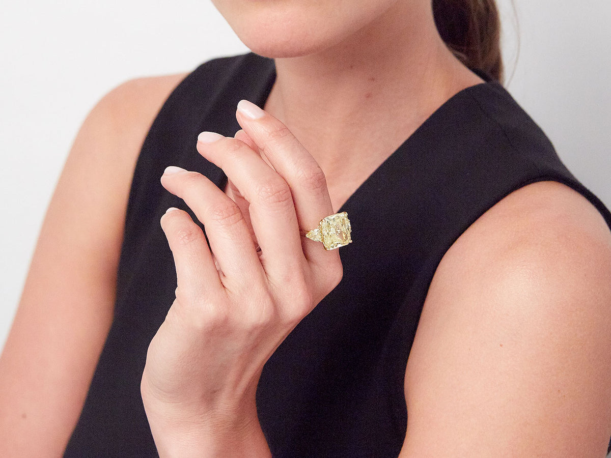 Woman wearing a yellow diamond ring with pear shaped accents