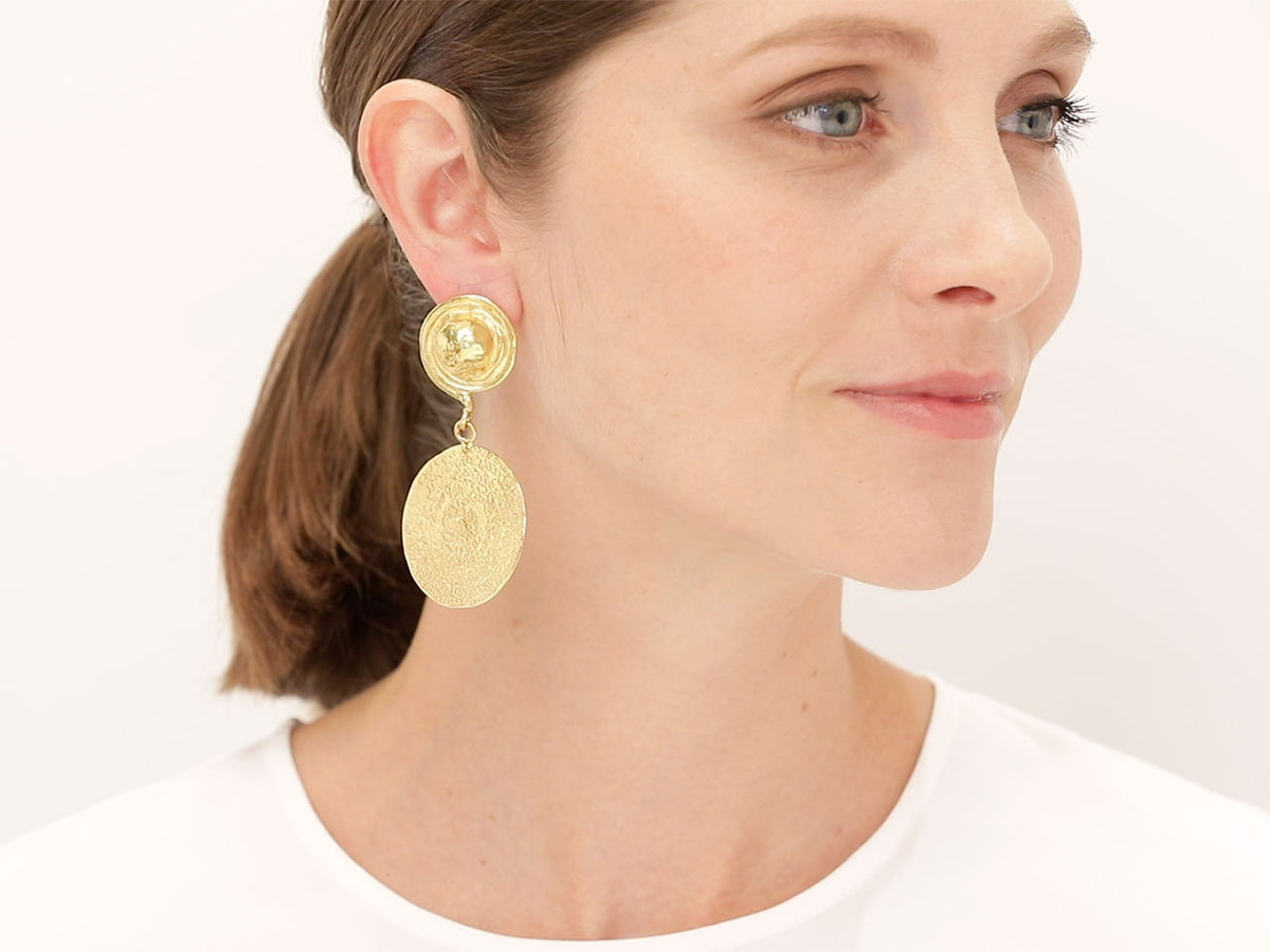 Woman wearing hand hammered 22K gold disc earrings