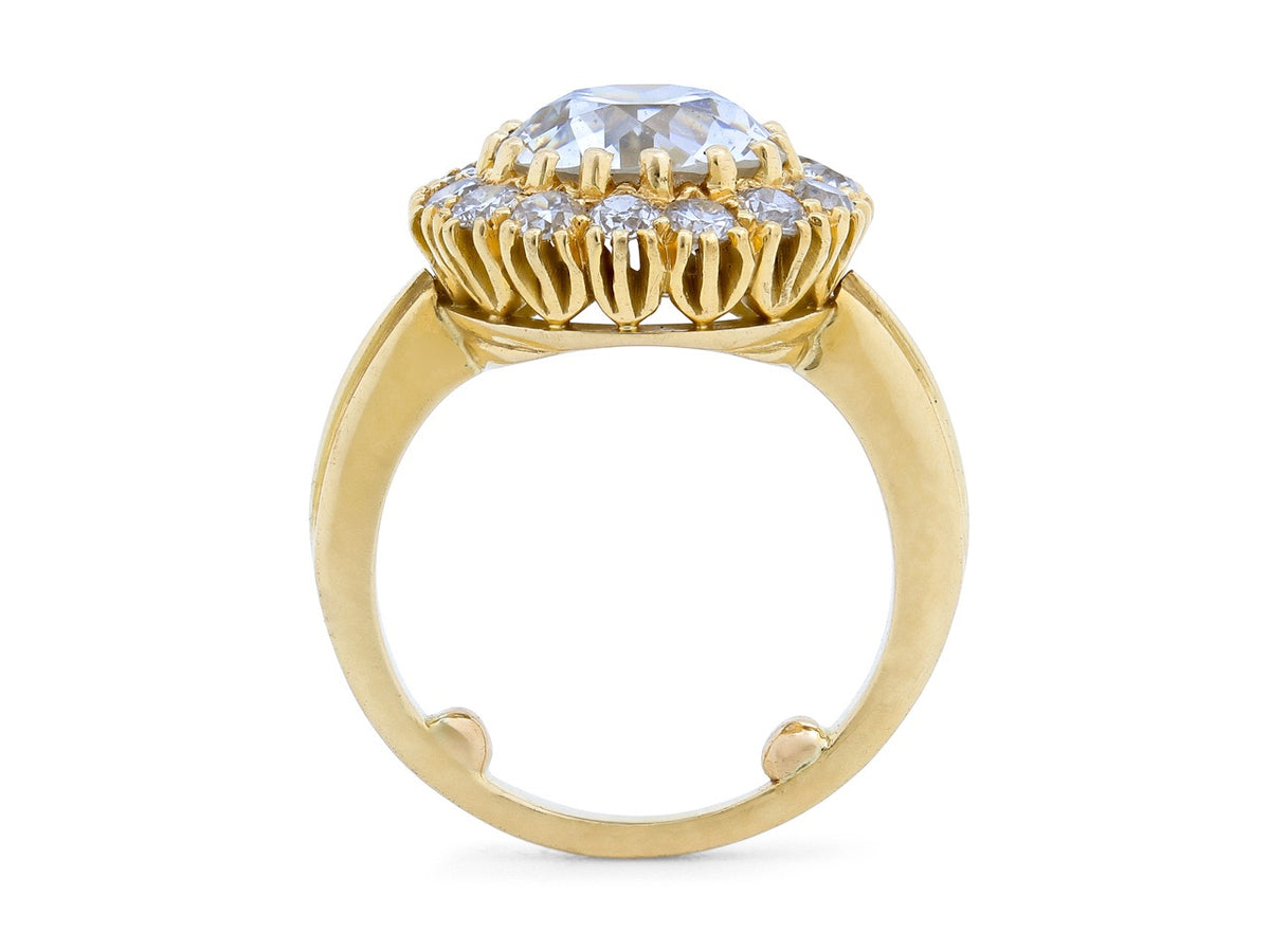 Side view of an 18K gold diamond halo ring