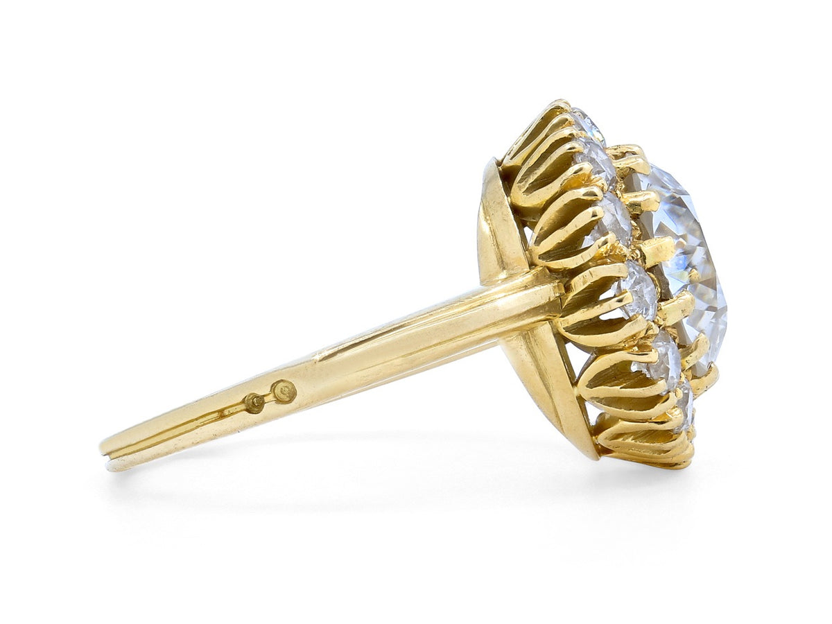 Side view of an 18K gold diamond halo ring