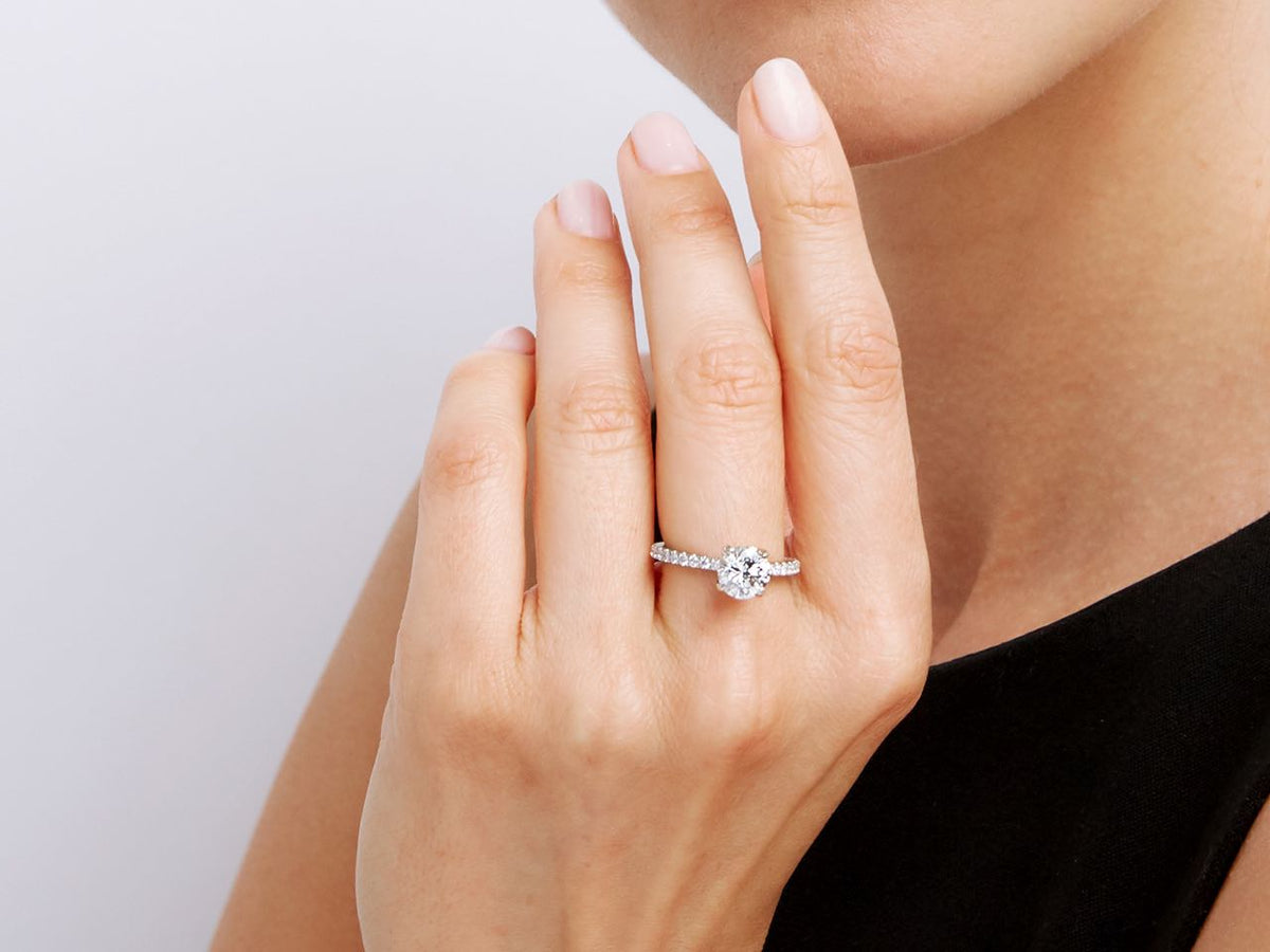 Woman wearing an 18K white gold diamond solitaire ring