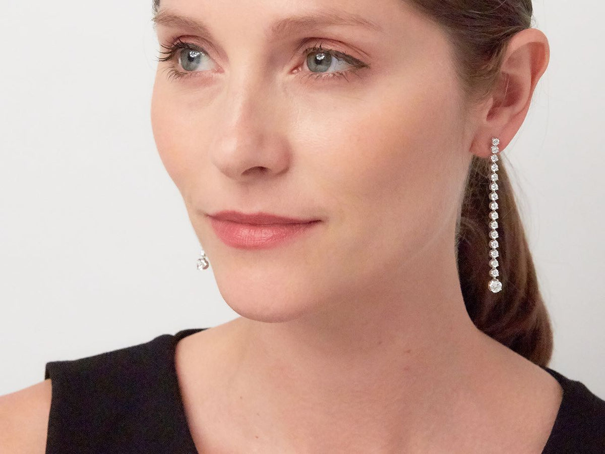 Woman wearing a long white gold diamond duster earring