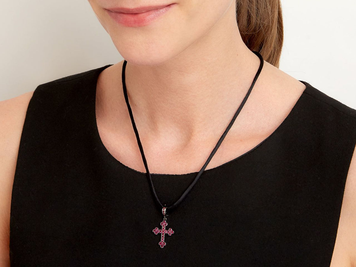 Ruby cross pendant on a black cord necklace