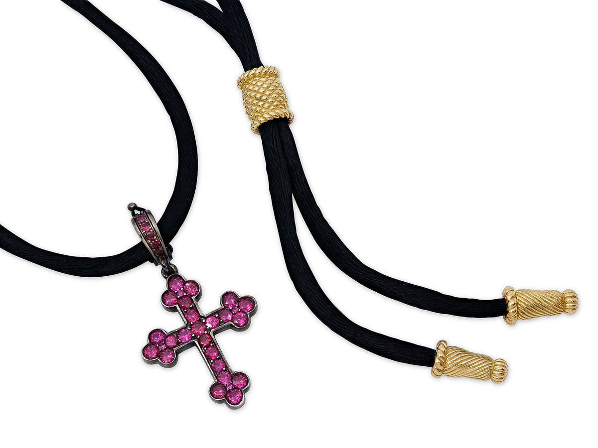 Ruby cross pendant on black cord with gold terminals