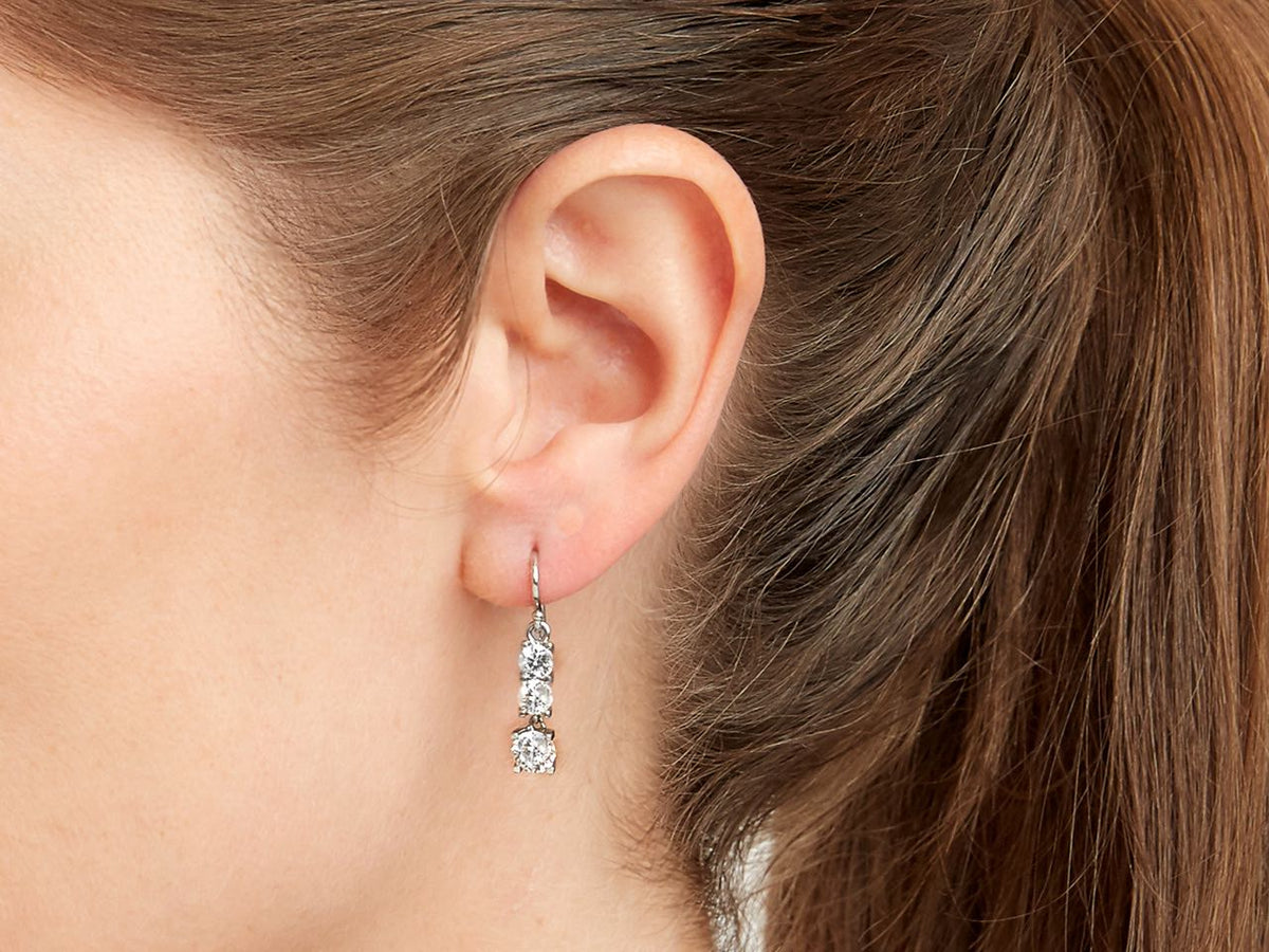 Close up of a woman wearing a dangling diamond earring