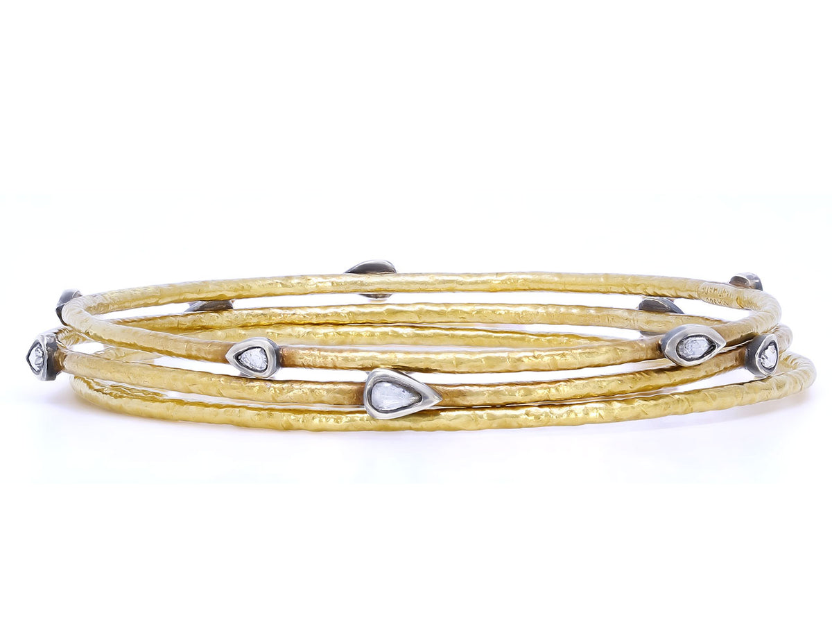 Three hammered gold bangles with silver diamond accents