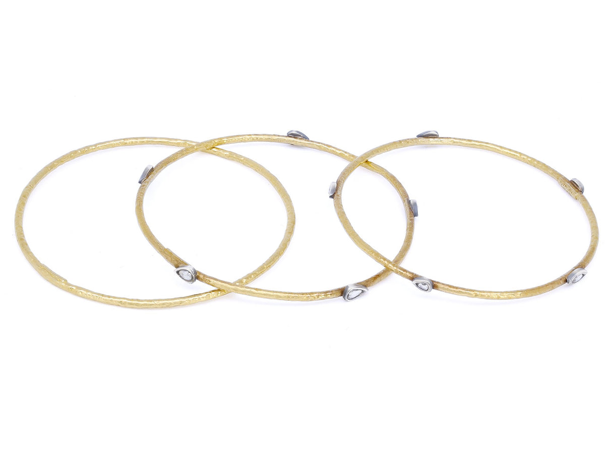 Three hammered gold bangles with silver diamond accents