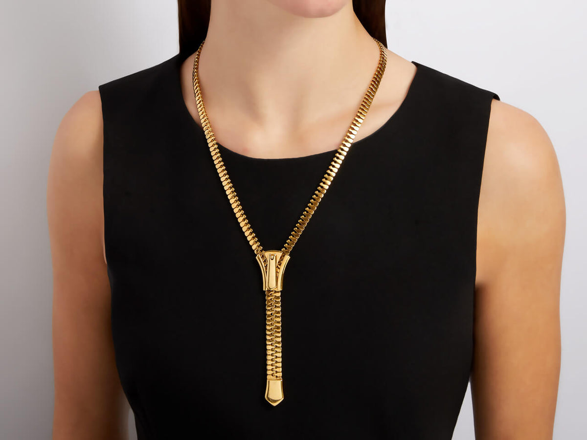 18K gold zipper necklace worn over a black dress