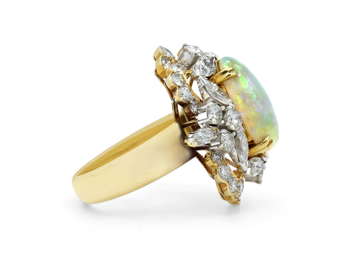 Side view of a white opal cabochon ring with diamond halo