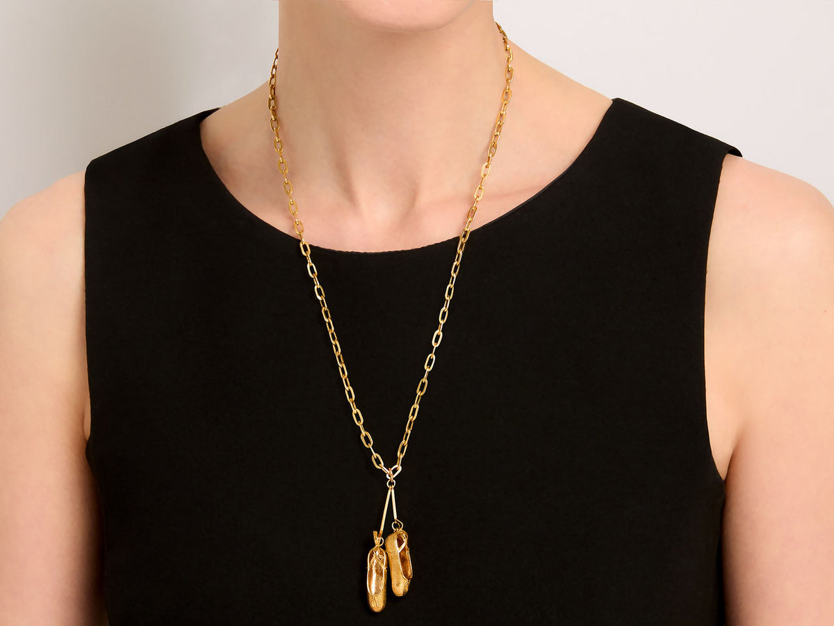 18K gold ballet slipper pendant necklace worn on black dress