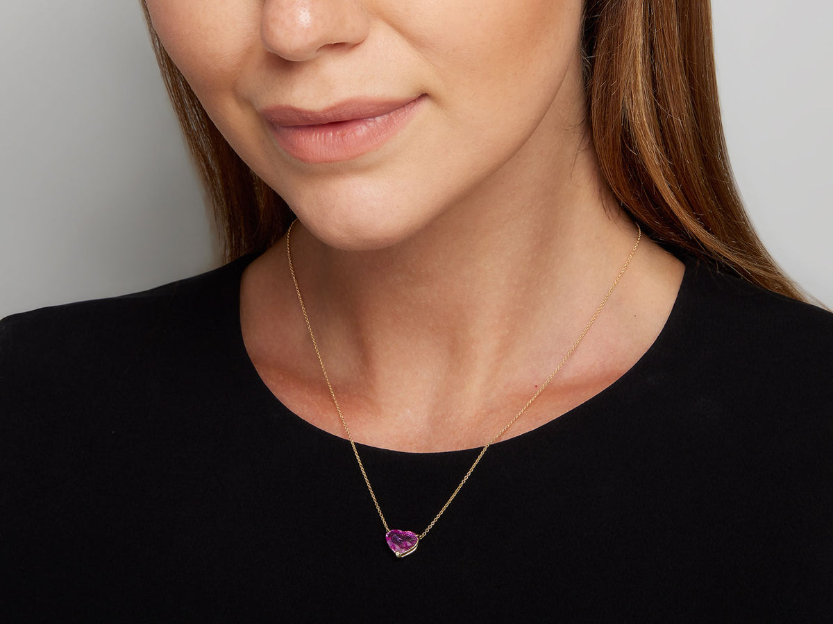 Heart shaped pink sapphire pendant on an 18K gold chain