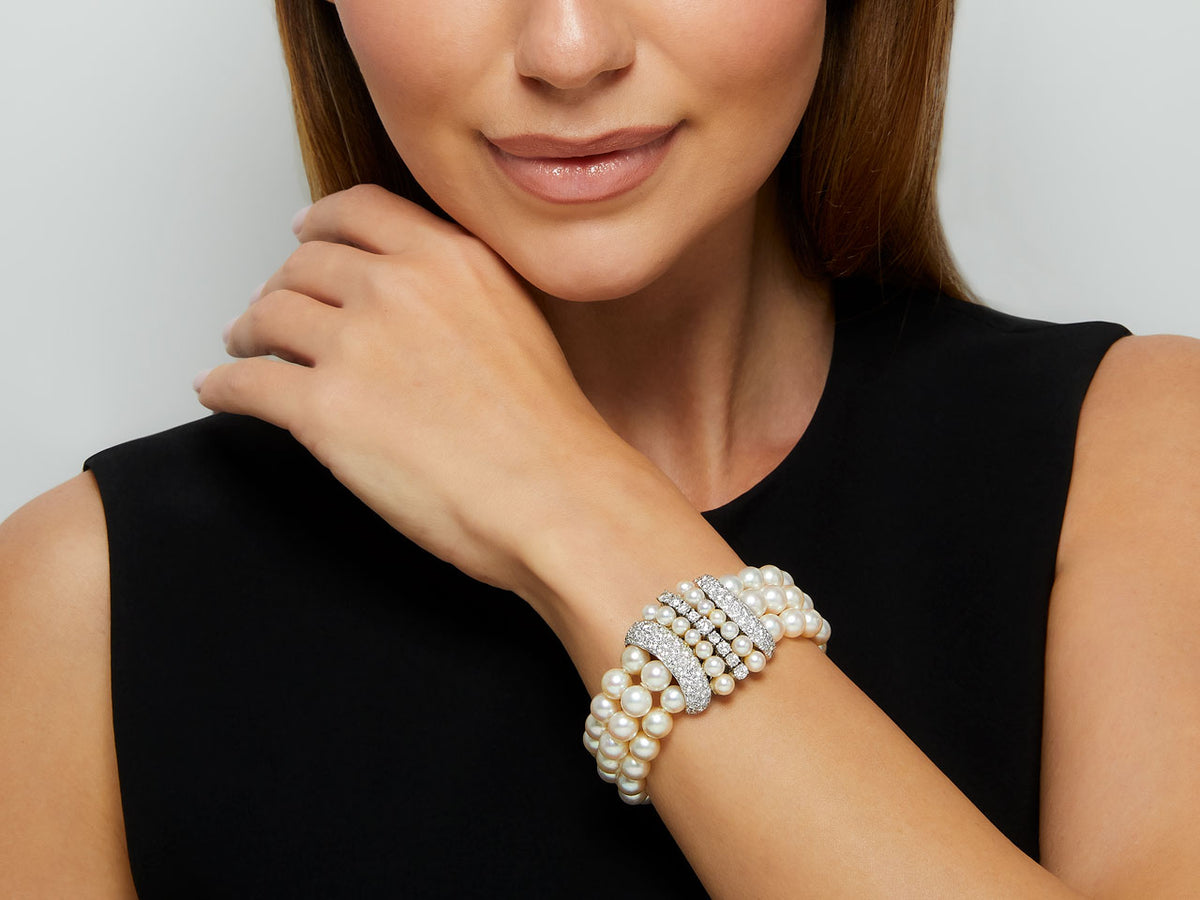 Woman wearing a three strand pearl and diamond bracelet