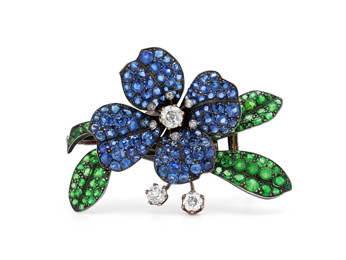 Flower brooch with blue sapphire petals green garnet leaves and dangling diamonds