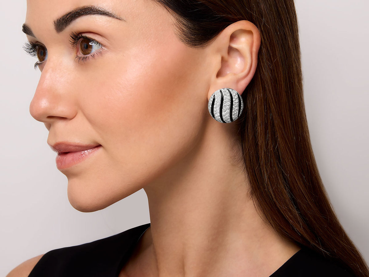 Woman wearing a round black onyx and diamond earring