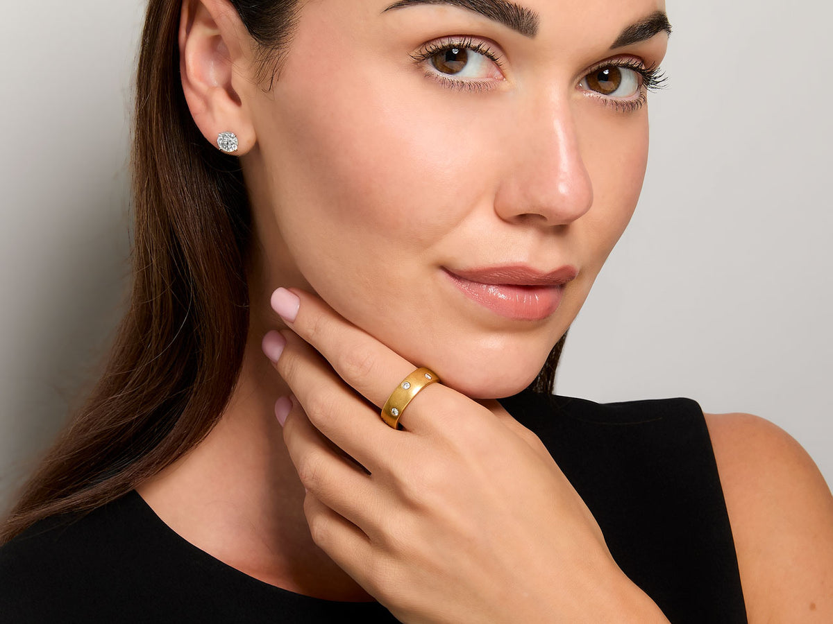 Woman wearing a brushed gold diamond band ring
