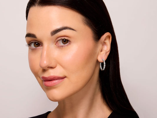 Tiffany & Co. Diamond Hoop Earrings in Platinum worn by a model, featuring hinged hoops with prong-set round brilliant diamonds from Beladora